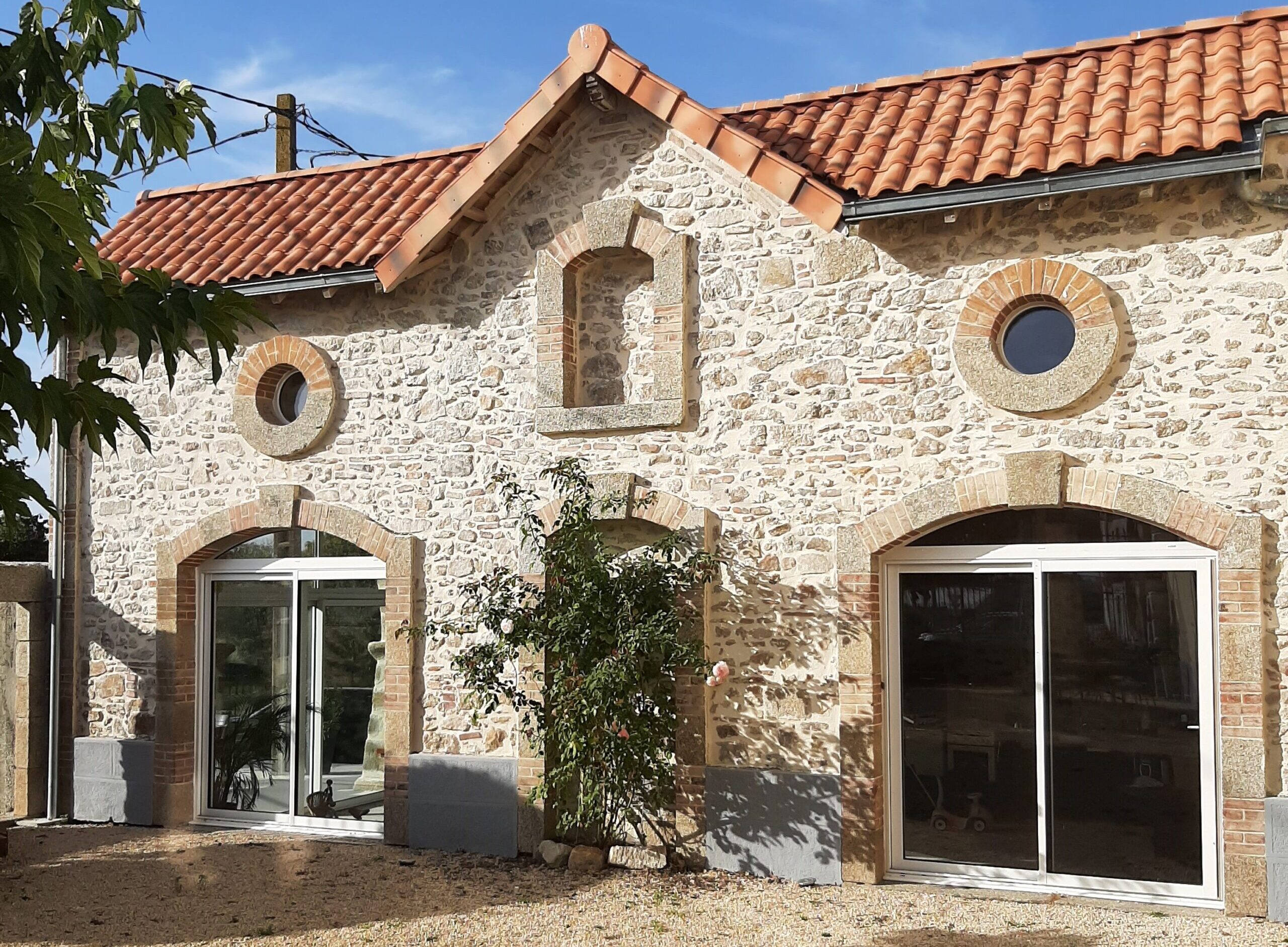 Devanture maison en pierre avec coulissant aluminium après rénovation